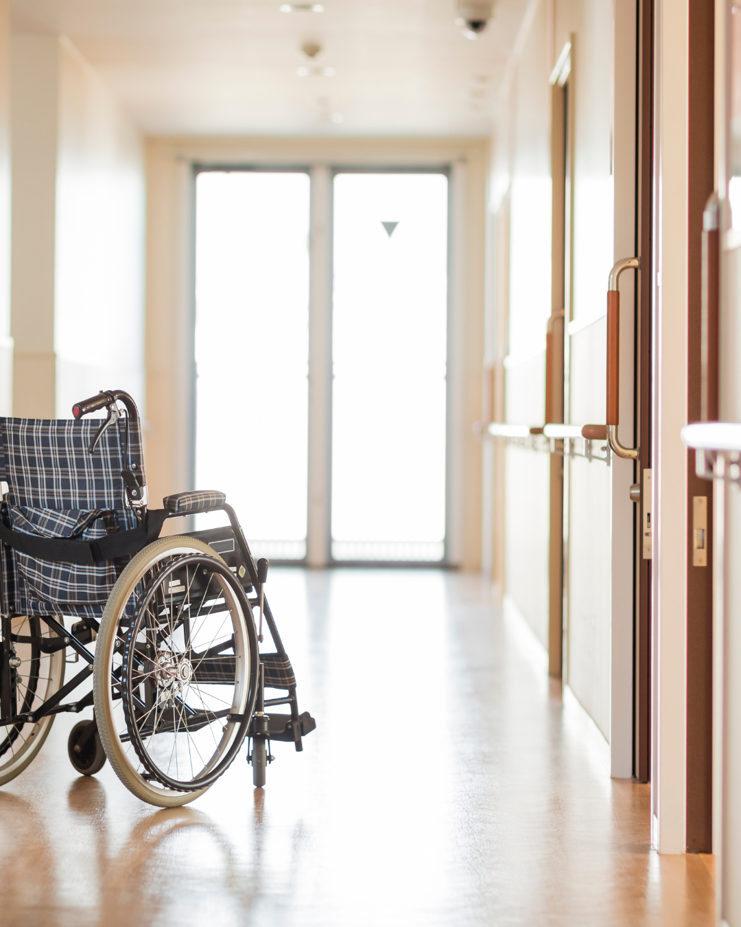Personne en fauteuil roulant dans un couloir d'établissement